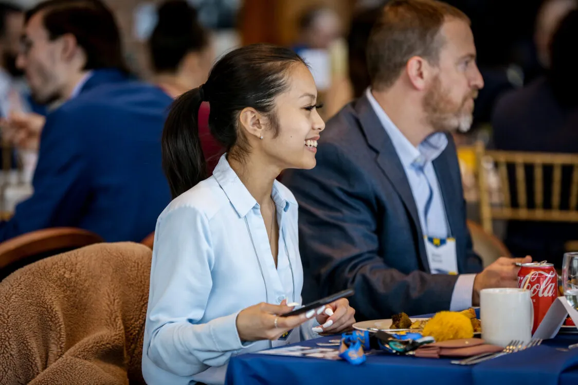 A smiling student talking to several people at the Blavin Scholars celebration.
