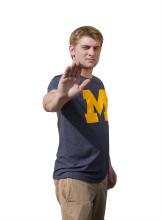 michigan student posing with hand out
